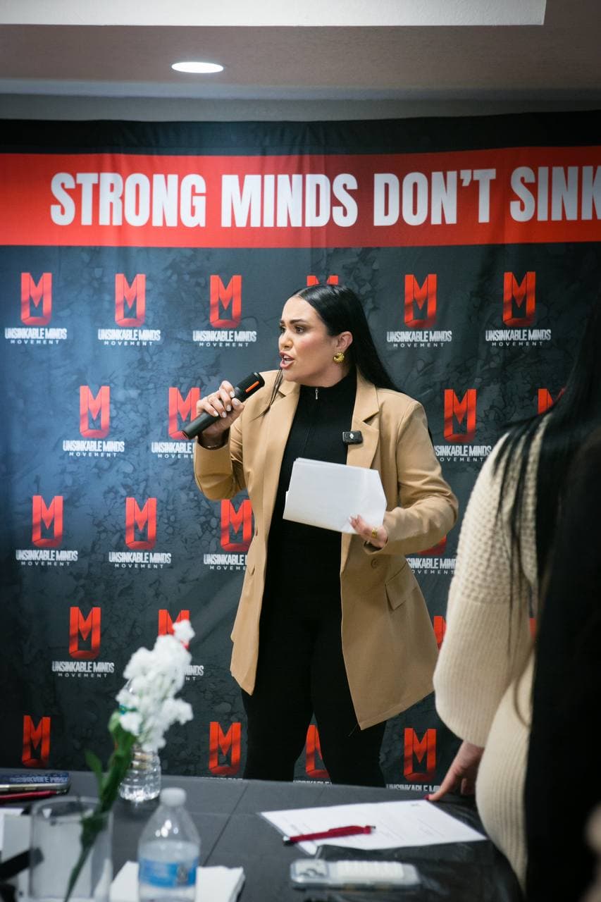 Dr. Gissele Donovan ante el backdrop del Movimiento Unsinkable Minds — Strong Minds Don't Sink