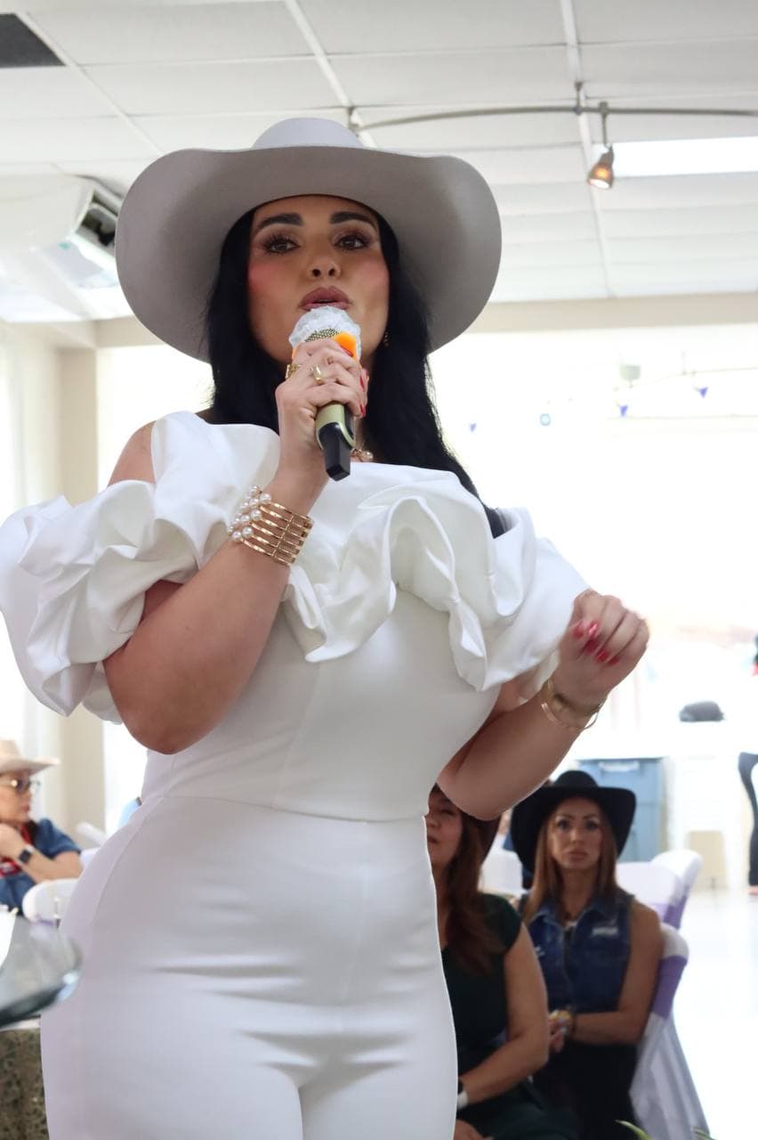 Dr. Gissele Donovan al micrófono — retrato editorial con sombrero blanco