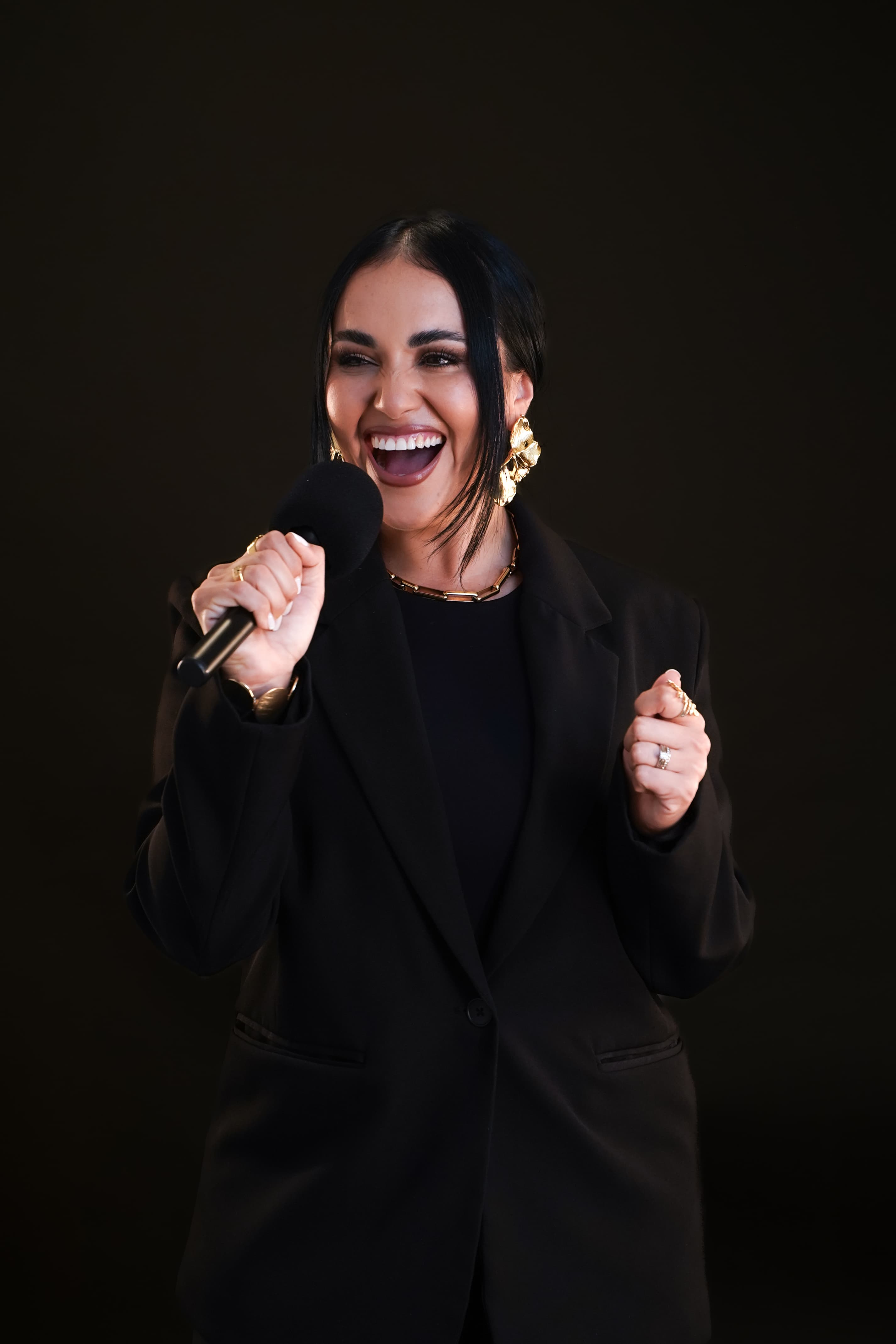 Dr. Gissele Donovan — joyful editorial portrait with microphone